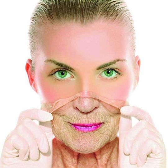 Una mujer adulta se deshace de las arrugas de su rostro con un tratamiento en el hogar